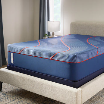 Lifestyle bedroom shot of the Sealy Posturepedic® Elite Albany II 13-inch Hybrid Medium Mattress on an upholstered bed frame in a warmly-lit bedroom