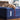 A relaxed dog resting comfortably on the plush blue quilted surface of the Sealy Posturepedic® Elite Albany 14-inch Firm Mattress, emphasizing the mattress's inviting comfort and supportive build, with the mattress's branding clearly visible.