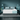 Front view of a Casper Snow Max mattress in a stylish bedroom setting featuring teal walls, matching hanging lamps, and side tables. The mattress is highlighted by its white surface and distinctive blue branding, complementing the modern, tranquil atmosphere of the room