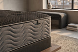 Jamison Clarion Firm mattress in a styled bedroom, close-up of the pillow-top edge and quilted side
