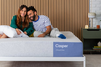 Couple sitting on a Casper Cloud One Mattress in a bedroom