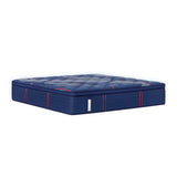 Full view of the Sealy Posturepedic® Elite Albany 15" Soft Euro Top Mattress in navy blue with a quilted top surface. The mattress features a plush pillowtop design with white diagonal striped patterns and button tufting across the sleep surface. Vertical red accent lines run along the sides of the mattress, highlighting its multi-layered construction. A Sealy brand tag is visible on the front side. The mattress is photographed at an angle against a white background, showcasing its substantial height