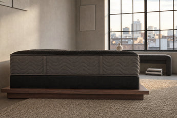 Jamison Clarion Firm mattress in a styled bedroom, side profile showing the mattress height